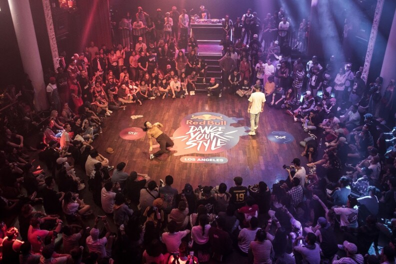 hundreds of people gather around two people dancing in the middle of a circle