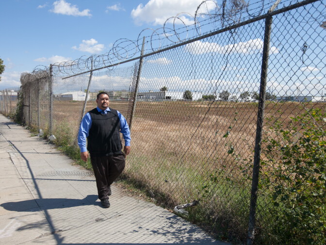 Andres Ramirez, community liaison for Community Health Councils Inc., walks along the vacant lot that used to be the South Los Angeles Farm, on Monday, April 6, 2015. 
