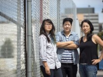 Protect Koreatown organizers TK Lê, left, Audrey Kuo and Lisa Fu stand outside an empty lot – the site of a 27-story residential development in Koreatown on South Catalina Street.