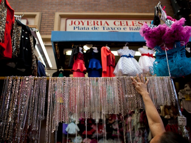 Stores put necklaces on display in Santee Alley as shoppers buy last-minute gifts on Christmas Eve.