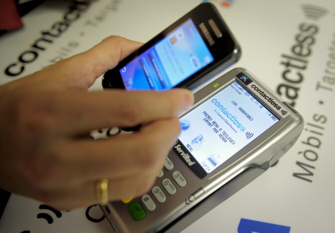 View of a smartphone displaying the "Contactless" application by Spanish bank La Caixa during it's presentation in Barcelona, on January 12, 2012. Spain’s biggest savings bank La Caixa has launched the world’s first ATMs to feature contactless technology. According to La Caixa, the ATMs will offer the fastest withdrawal system on the market. AFP PHOTO / JOSEP LAGO (Photo credit should read JOSEP LAGO/AFP/Getty Images)