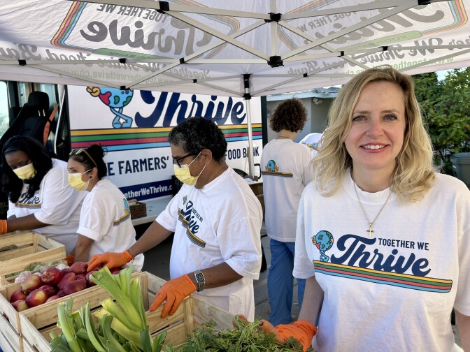Female presenting person has blonde hair and wears a white t-shirt.