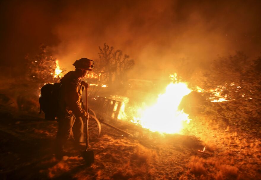 A firefighter watches the Blue Cut wildfire burning near Cajon Pass, north of San Bernardino, California on August 16, 2016. 