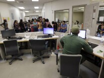 FILE - This June 18, 2014, file photo, U.S. Customs and Border Protection agents work at a processing facility in Brownsville,Texas. Immigration courts backlogged by years of staffing shortages and tougher enforcement face an even more daunting challenge since tens of thousands of Central Americans began arriving on the U.S. border fleeing violence back home.  (AP Photo/Eric Gay, Pool, File)