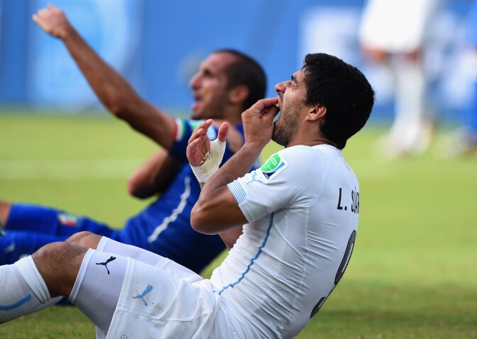 Luis Suarez of Uruguay and Giorgio Chiellini of Italy react after a clash during the 2014 FIFA World Cup Brazil Group D match between Italy and Uruguay at Estadio das Dunas on June 24, 2014 in Natal, Brazil.  