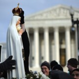 A marcher places a crown atop a statue of the Virgin Mary as she is carriedinfront of the US Supreme Court during the March for Life on January 24, 2011 on Capitol Hill in Washington, DC.The march marks the 38th anniversary of Roe v. Wade (officially Jan. 22), a landmark Supreme Court decision that legalized abortion.     AFP PHOTO / Tim Sloan (Photo credit should read TIM SLOAN/AFP/Getty Images)