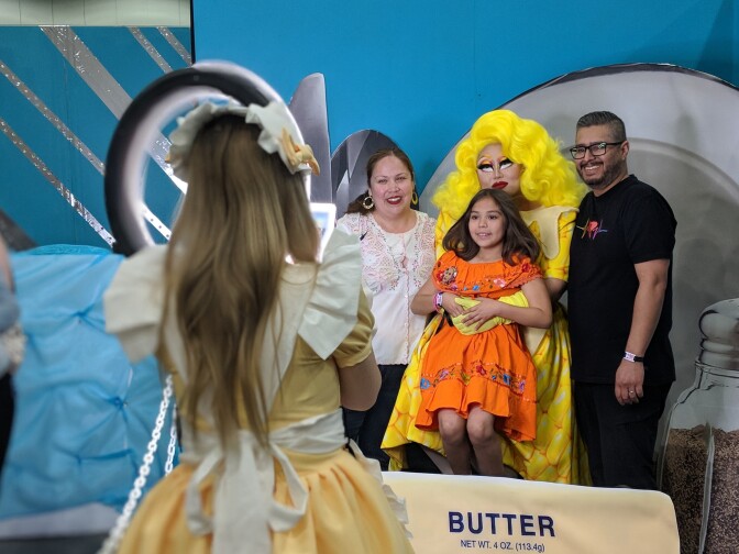 Drag queen Kim Chi, in yellow, poses with her fans during RuPaul's DragCon LA 2018. Parents Lorena Garcia-Marquez (L) and Roberto Marquez (R) brought their 8-yo Sophie Marquez to the event.