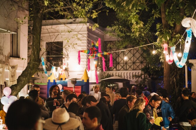  A stream of lights and a piñata hang over the patio as attendees arrive to the party.
