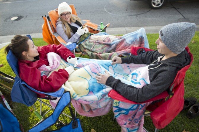People in camp chairs on a grassy area 