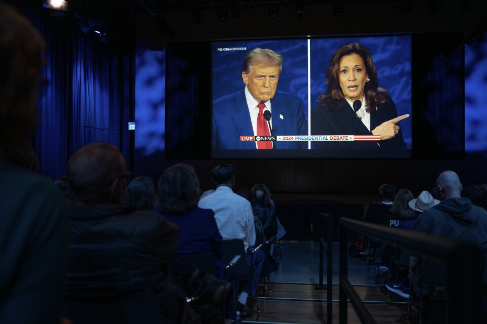 People in a room watch a presidential debate.