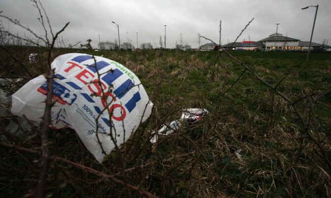 File: A plastic bag is caught in bushes outside a supermarket.