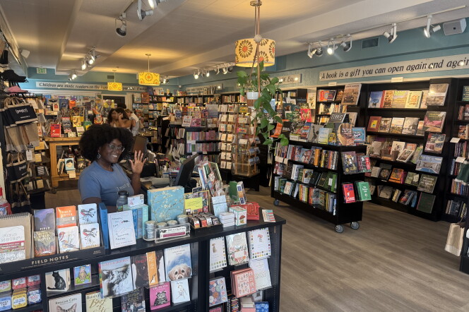 A woman in a blue shirt stands in pages: a bookstore. She is surrounded by books on all sides.