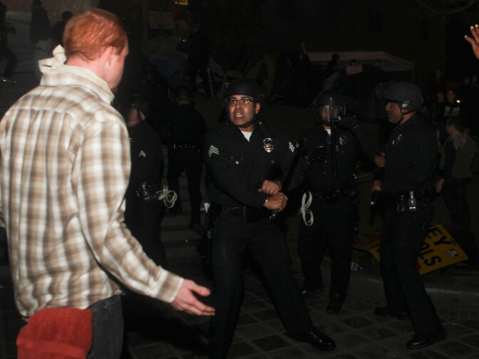 An LAPD officer threatened a demonstrator as police swarmed the plaza and encircled the protesters.