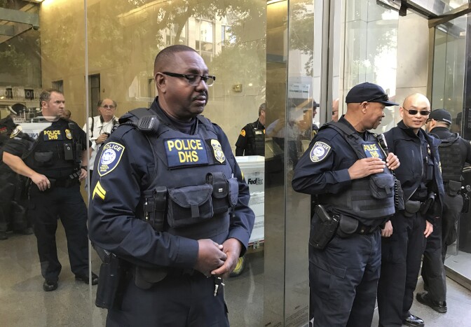File: Officers from the Department of Homeland Security's Federal Protective Service stand guard as people demonstrate outside a federal immigration court in Los Angeles on Monday, March 6, 2017, protesting the arrest of an immigrant who has been ordered deported. Romulo Avelica-Gonzalez was arrested Feb. 28 after dropping his daughter off at school in Los Angeles.