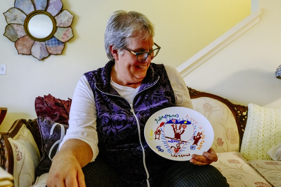 Audrey Woolfolk holds a plate that Julie decorated for a Mother's Day gift when she was younger. 