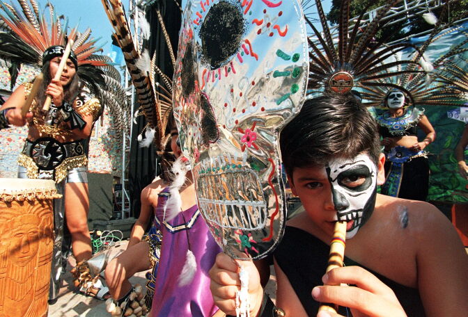 LOS ANGELES, UNITED STATES:  A boy plays the flute during a celebration of "The Day of the Dead"  01 November in East Los Angeles. The festival, both secular and religious, Catholic and pre-Columbian, is celebrated mostly by the Hispanic community of Los Angeles. Most other communities celebrate Halloween 31 October.   AFP PHOTO/Hector MATA (Photo credit should read HECTOR MATA/AFP/Getty Images)
