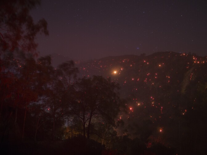 A smoldering mountainside is seen under a starry sky at the Thomas Fire on December 16, 2017 in Montecito, California.