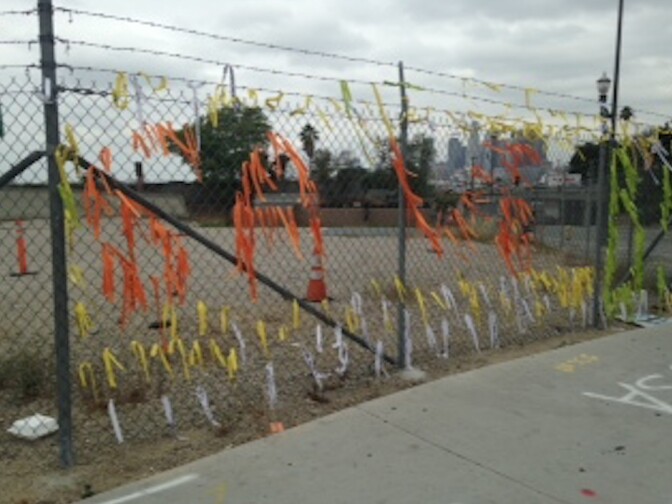 Ribbons written with protestors' wishes for what they'd like to see in Boyle Heights were attached to a fence surrounding the apartment construction site in March. Developers say the Santa Cecilia Apartments will have affordable housing units once they open next year. But locals worry about longtime residents' displacement and a lack of infrastructure in the neighborhood.