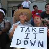 COLUMBIA, SC - JUNE 23:  Gwen Alston, Kuniharu kubodera and Barbara Kubodera (L-R) sit on the steps of the capitol as they show their support for the removal of the confederate flag from the Capitol grounds, during a protest in support of the flags removal on June 23, 2015 in Columbia, South Carolina. The South Carolina governor Nikki Haley asked that the flag be removed after debate over the flag flying on the capitol grounds was kicked off after nine people were shot and killed during a prayer meeting at the Emanuel African Methodist Episcopal Church in Charleston, South Carolina.  (Photo by Joe Raedle/Getty Images)