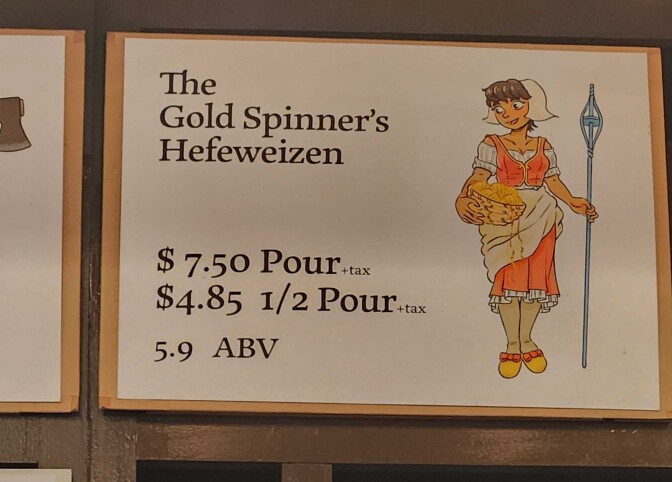 A sign at RT Rogers reads The Gold Spinner's Hefeweizen. Below the price and alcohol content is listed. On the right side is an illustration of the miller's daughter from the fairytale Rumpelstiltskin and she carries a basked of gold yarn. 