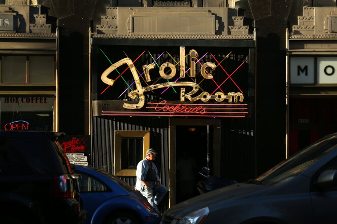 A person is outsid the entrance to the Frolic Room during the day.