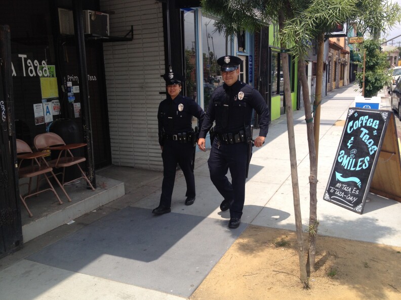 LAPD Officers Jennifer Aguilar (L) and Miguel Ruano walk down First Street in Boyle Heights. The foot patrols are an effort to build community relations in the Hollenbeck Division.