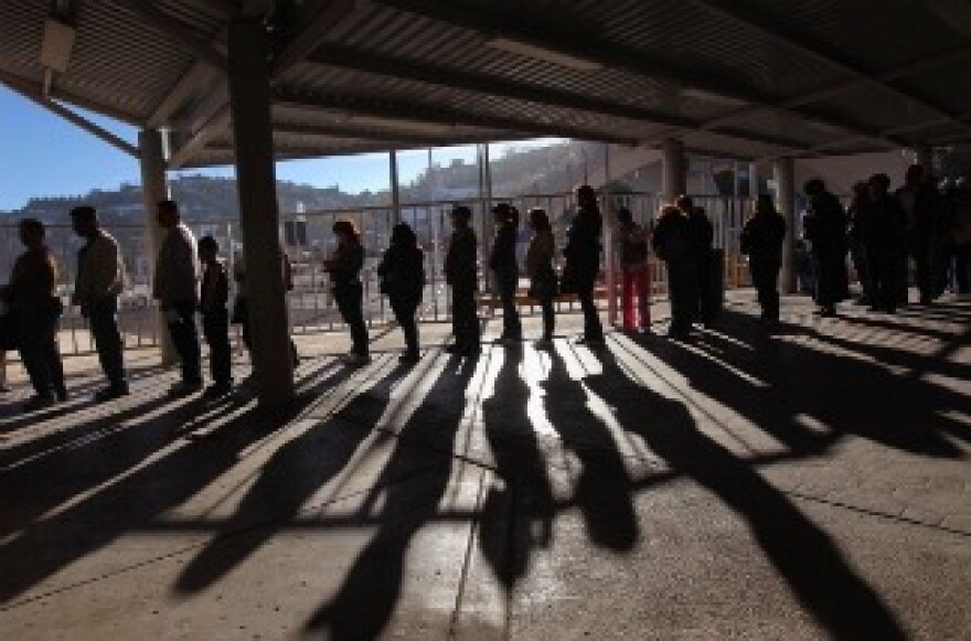 Hundreds of people wait to pass from Mexico into the United States at the border crossing on December 10, 2010 at Nogales, Arizona. Despite Arizona's tough immigration enforcement laws, thousands of Mexican citizens have permits to work in the U.S. and commute daily from their homes across the border in Mexico.