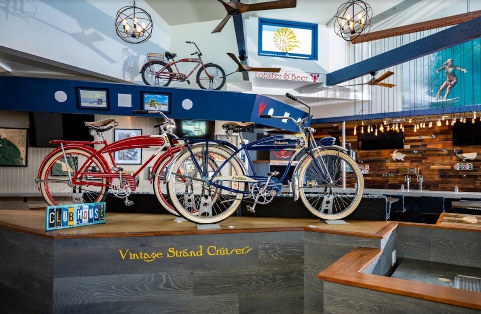 The interior of a bar with two retro bicycles on display, and other vintage cycling items hanging from the walls and ceilings. 