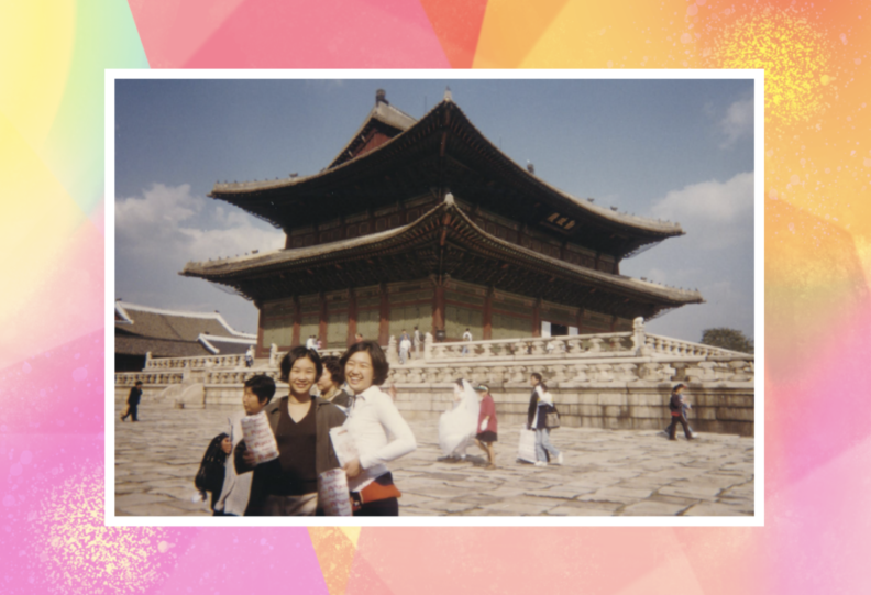 A color photo shows two young women standing in front of an ancient-looking building of classic Asian-style architecture, with other people behind them.