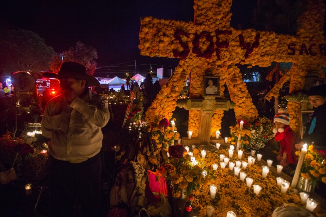 People attend to the graves of loved ones on the eve of the Day of the Dead at the cemetery of Tzintzuntzan in Patzcuaro, Michoacan, Mexico on November 1, 2016.