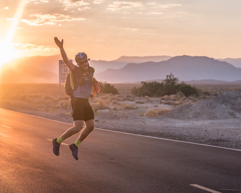 Bike and Build cyclist Sean Triser celebrates after entering California.