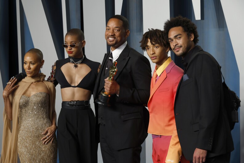 Will Smithm center, is surrounded by his family while holding his Oscar for best male actor in a leading role.
