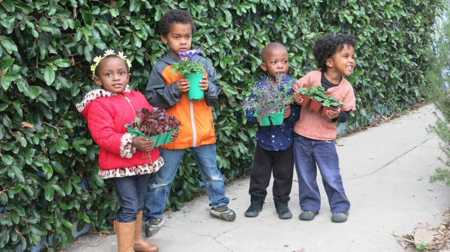 Children don pots of plants in Ron Finley's urban garden in South Central L.A.