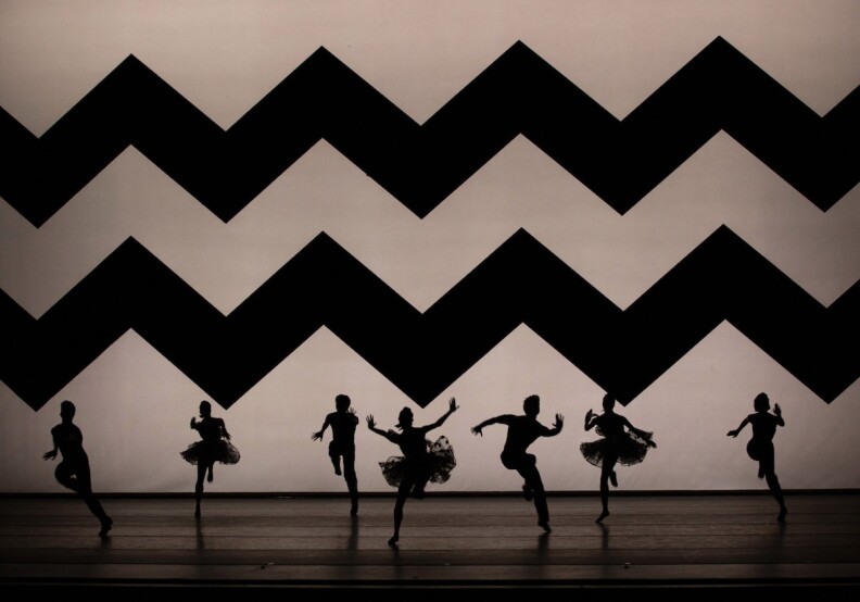 Ballet Dancers in Silhouette set againt a giant Zig Zag background.