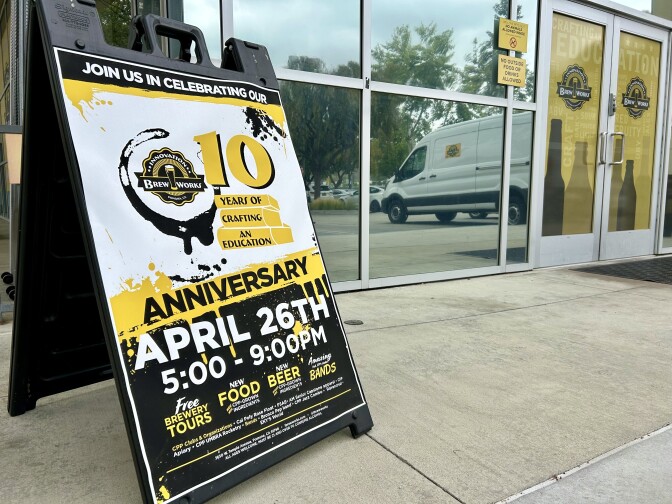 A banner with the words "anniversary" and "10 years of crafting an education" rests in front of the entrance to a building.