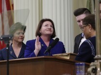 Toni Atkins, D-San Diego, second from left, smiles as she looks up to friend seated in the Assembly Gallery as she is sworn in as 69th Assembly Speaker by former Assembly Speaker, Rep. Karen Bass, D-Calif., right, at the Capitol in Sacramento, Calif., Monday, May 12, 2014.  Atkins replaces Assembly Speaker John Perez, D-Los Angeles, who is termed out.  Atkins was accompanied by her spouse, Jennifer LeSar, left, and her nephew, Thomas Phillips, second from right.(AP Photo)