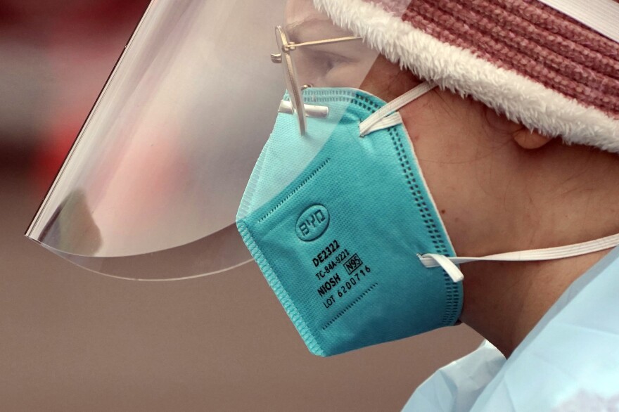 Linsey Jones, a medical assistant working at a drive-up COVID-19 testing clinic, wears an N95 mask on Jan. 4, in Puyallup, Wash. The Biden administration will begin making 400 million N95 masks available for free to Americans starting this week.