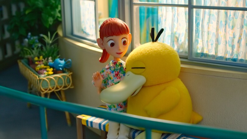 A spot-motion animated person sits next to a duck-like creature.