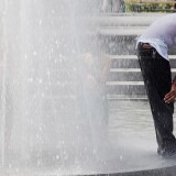 NEW YORK, NY - JULY 18:  A man stands in a fountain in Washington Square Park on July 18, 2012 in New York City. Temperatures were expected in the upper 90's during another heat wave in the city.  (Photo by Mario Tama/Getty Images)