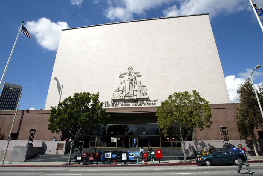 The exterior of the courthouse has a blocky windowless facace above the entryway with an emblem of Lady Justice embedded into the stone.