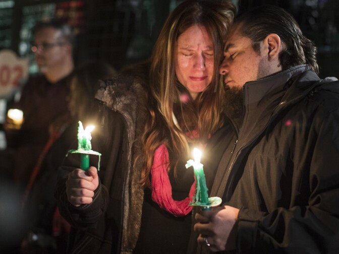 Jennifer and husband Roy Trules cry as the names of victims are read aloud during a moment of silence concluding a vigil at San Manuel Stadium in San Bernardino on Thursday night, Dec. 3, 2015. Both were friends with 26-year-old Aurora Godoy of San Jacinto. Roy Trules first met Godoy more than three years ago when they both worked for the San Bernardino County Registrar of Voters.