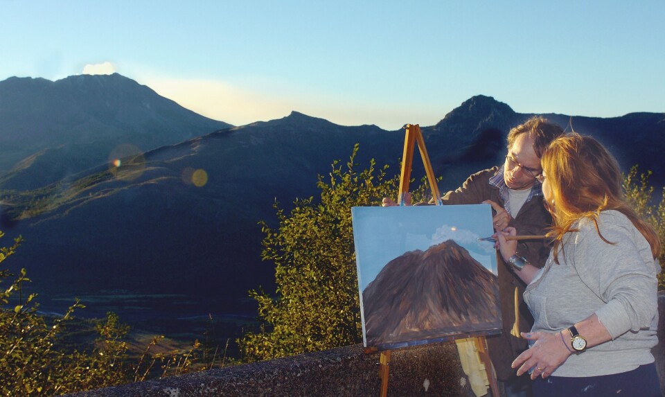 Teri Dewey, right, assisted by her husband, Joe Dewey, adds a steam plume to her painting of Mount St. Helens, after setting up her easel at Elk Creek Overlook in Washington on October 14, 2004.