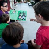 Children's Center teacher Karina Diaz reads a book to preschoolers on Tuesday afternoon in the center's large outdoor space.