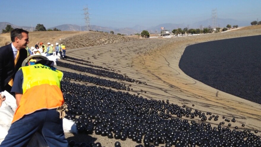 Los Angeles Mayor Eric Garcetti helps to release shade balls into the L.A. Reservoir.