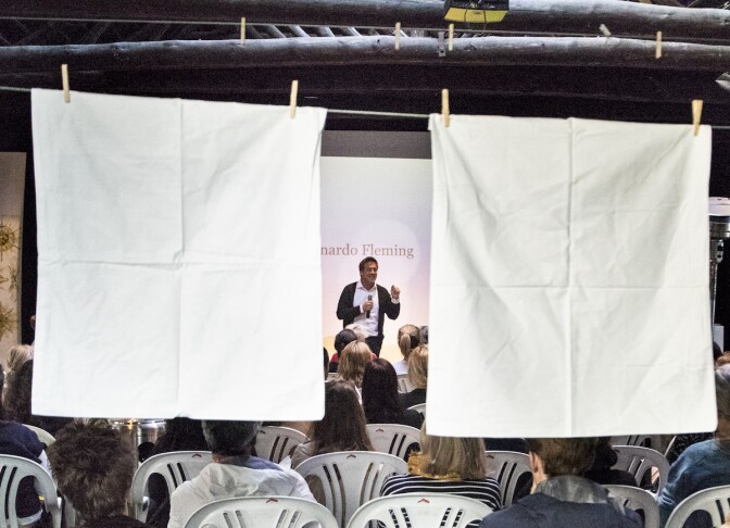 A man stands on a sheet between two large white sheets