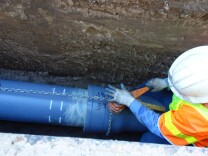 A DWP worker winches a section of earthquake resistant pipe into place below Reseda Blvd. near the Northridge Medical Center.
