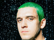 A man with green hair in simulated rain.