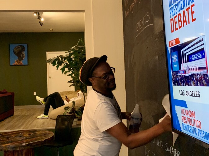 Lawrence Ross draws up a scoreboard for the Dec. 19, 2019 Democratic Presidential Debate watch party at co-working space The Metaphor Club. 