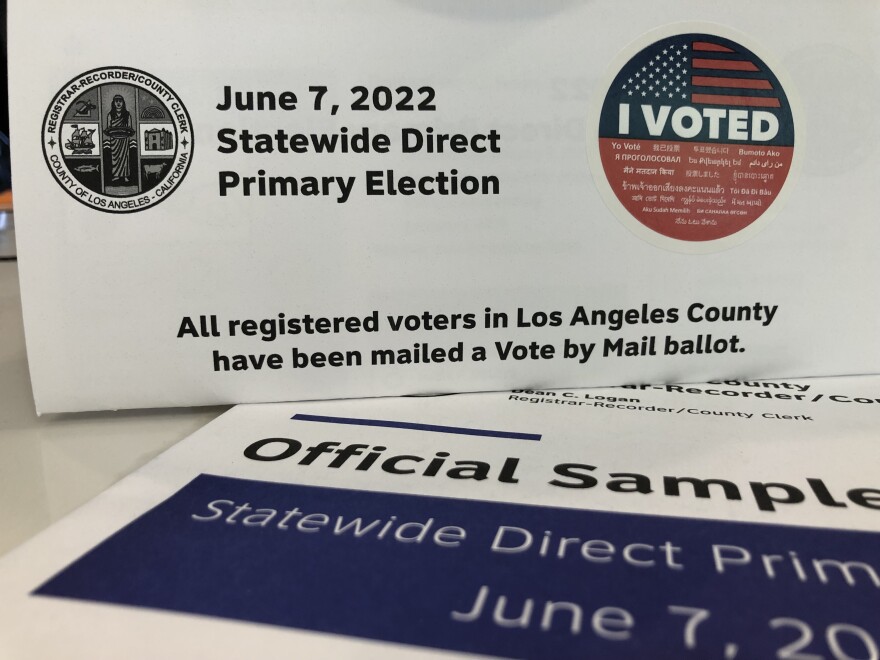 A mail-in ballot with an "I voted" sticker rests on top of the official ballot guide