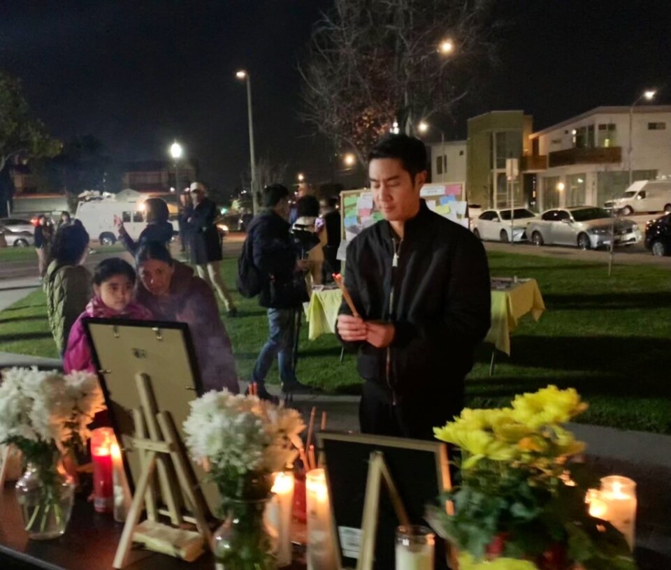 An Asian American man burns incense at an altar set up for victims outside Monterey Park City Hall.